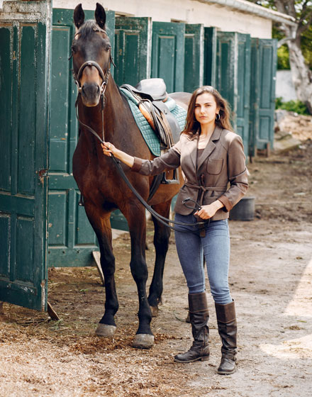 Fid'Equin : Photo avec au centre d'une écurie, une cavalière avec son cheval.