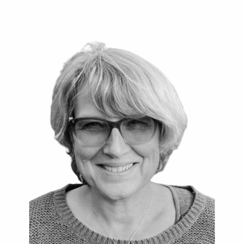 Fid'Equin : Photo en noir et blanc d'une femme qui regarde l'objectif, droit devant. Elle porte une paire de lunettes teintées et un collier. Les cheveux sont blanc et courts avec une frange.