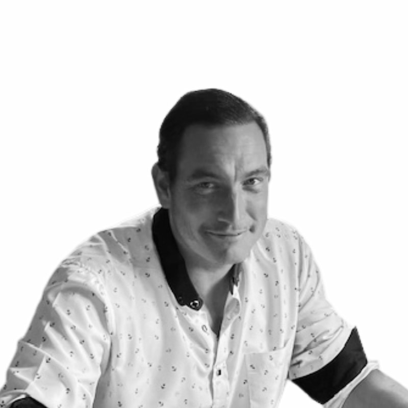 Fid'Equin : Photo en noir et blanc d'un homme un peu en biais qui regarde devant lui. Sa chemise est blanche avec des petits motifs plus foncés.